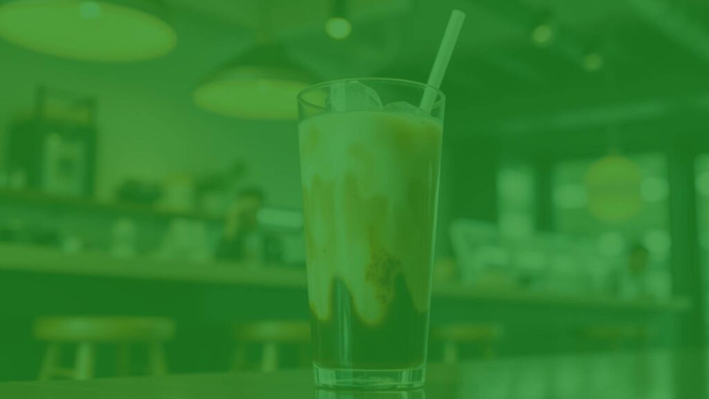 A refreshing iced macchiato with clear layers of espresso and milk, served in a tall glass with ice cubes, bright lighting, modern coffee shop setting, realistic.