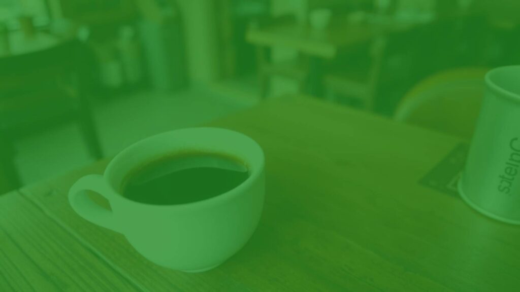 A small cup of ristretto coffee, dark and concentrated, with rich crema on top, placed on a rustic wooden table in an Italian café, warm lighting, realistic.