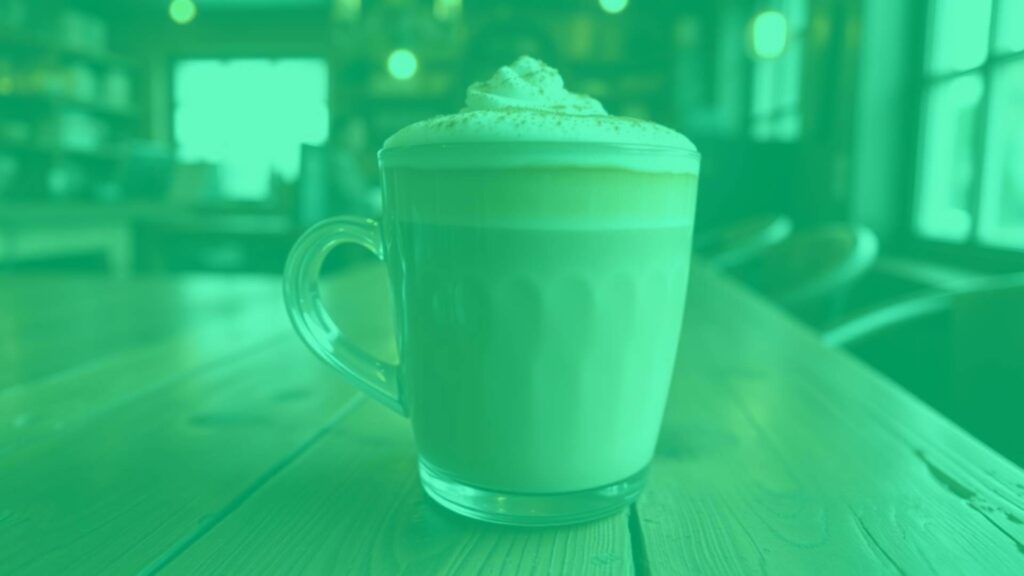 A dirty chai latte in a ceramic mug with a creamy microfoam top, dusted with cinnamon, placed on a rustic wooden table, warm lighting, spiced tea and espresso flavors blending, cozy coffeehouse ambiance, hyperrealistic.