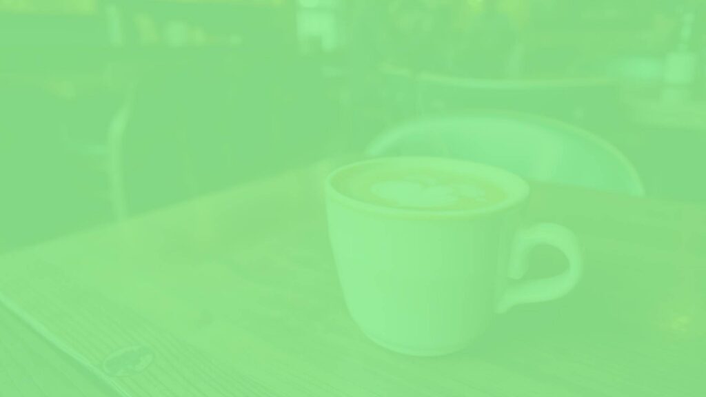A steaming ginger latte in a ceramic cup, warm and inviting, with espresso, steamed milk, and ginger spice, set on a rustic wooden table in a cozy Italian cafe.