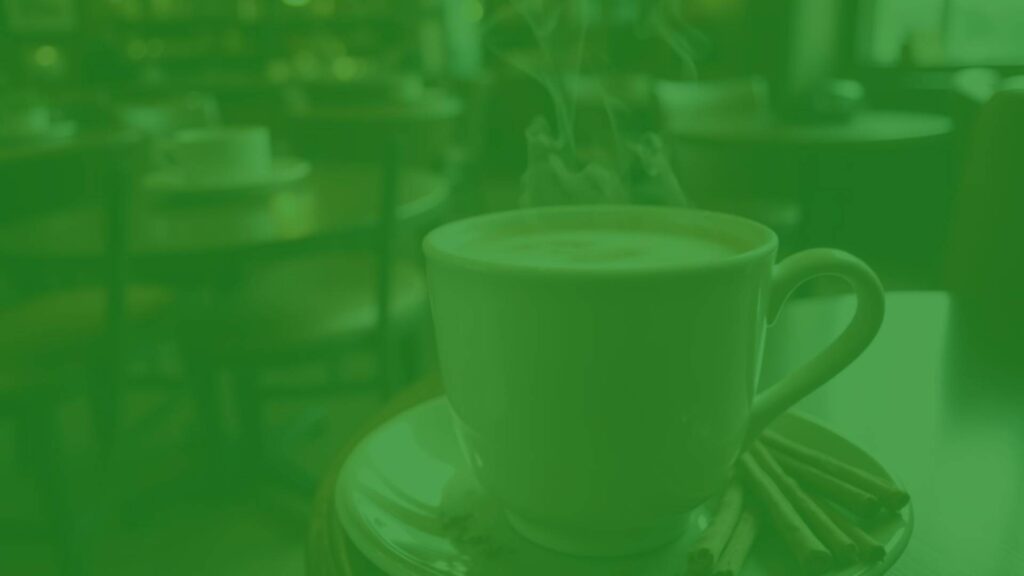 Aromatic vanilla chai latte in a ceramic mug, steam rising, warm spices visible, cozy cafe setting, soft lighting, inviting and elegant.