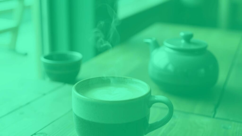 A warm and inviting hojicha latte in a ceramic mug, steam rising, with a light foam top, rustic wooden table background, soft natural lighting, cozy and calming atmosphere.